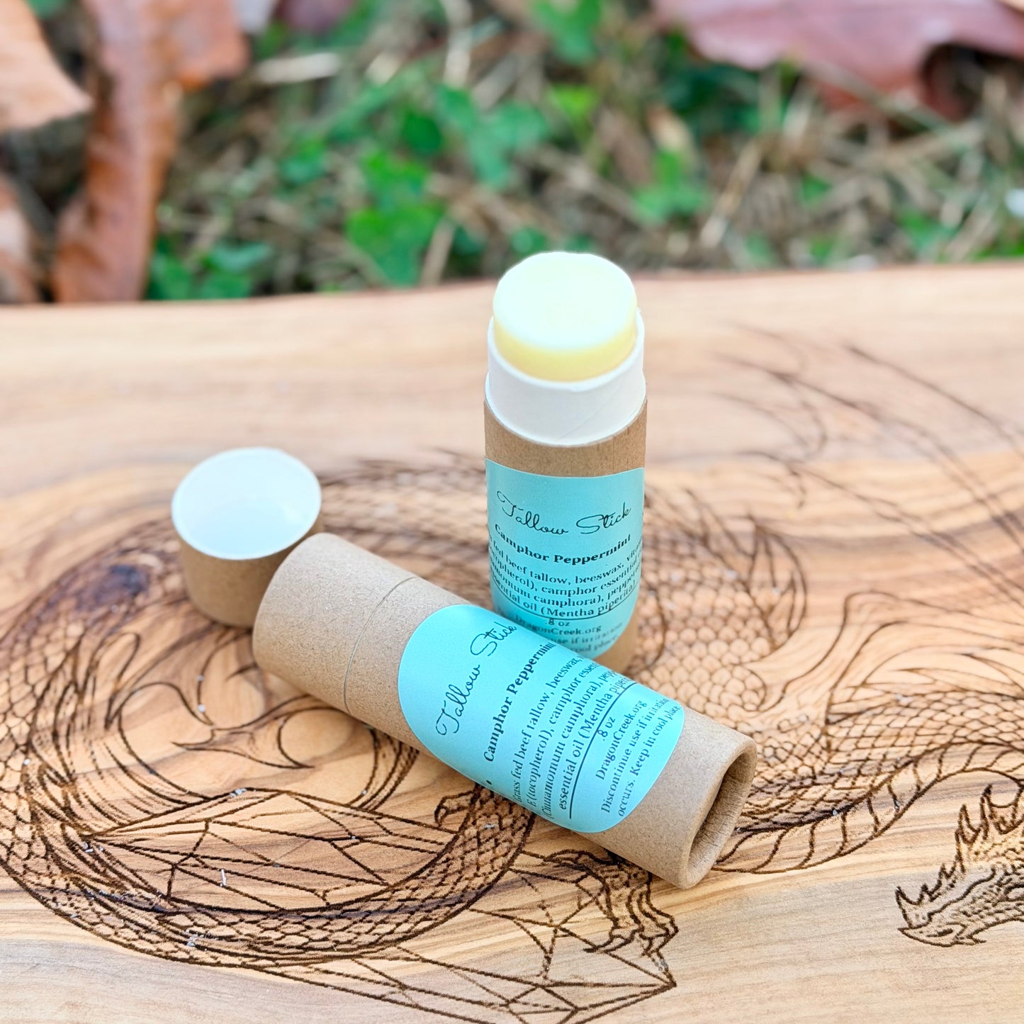 Two large ip balm sticks with labels on a wooden surface