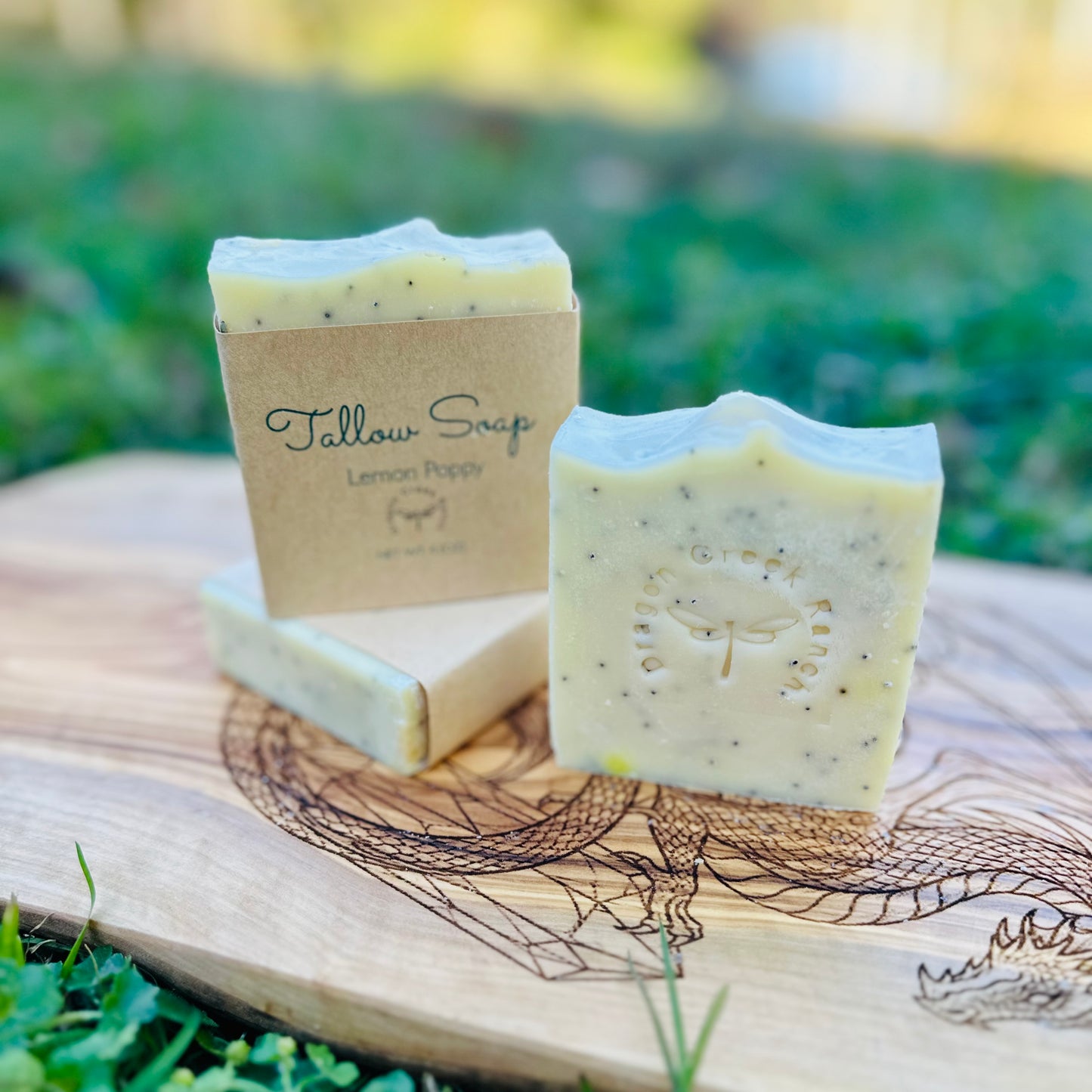 Two bars of lemon poppy soap on a wooden board with a natural background