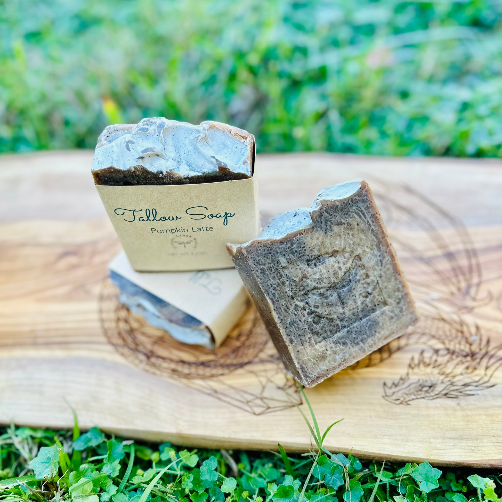 Brown colored tallow soap with packaging on a wooden surface outdoors